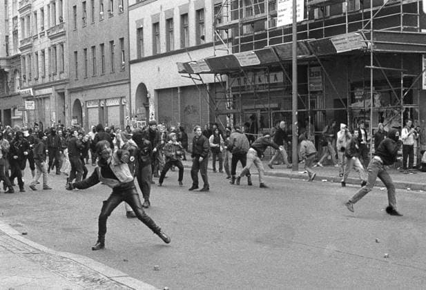 Vermummte Demonstranten werfen Steine gegen die Polizei am 1. Mai in Berlin-Kreuzberg