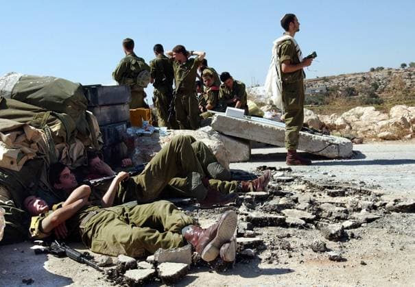 Israelische Soldaten einer Schutztruppe nutzen die Pause zum Dösen und Beten an einer Straßensperre bei der Siedlung Kiryat Arba -  jer2003101401