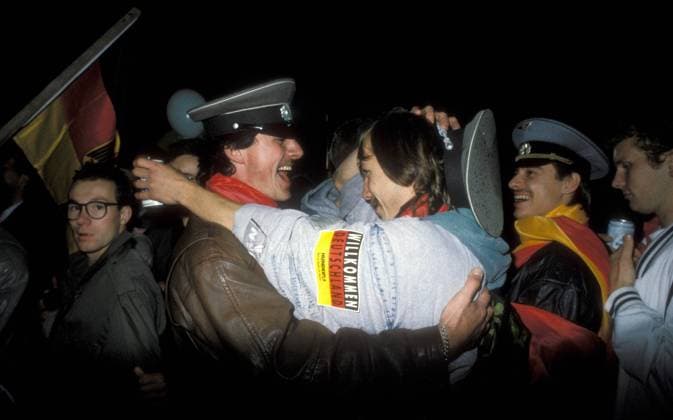 POLITIK 25 Jahre Deutsche Einheit: Die Wiedervereinigung Männer umarmen mit sich Mützen der NVA während der Feierlichkeiten zum Tag der Deutschen Einheit in Berlin