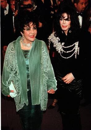 Schauspielerin Elizabeth Taylor (li.) und Sänger Michael Jackson (beide USA) Hand in Hand auf dem Weg zu einer Veranstaltung im Pantages Theatre in Los Angeles -  (LAP97021602)