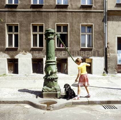 Kind mit Hund an einer Wasserpumpe am Arkonaplatz in Berlin-Prenzlauer Berg
