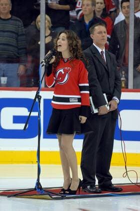Schauspielerin Emmy Rossum (USA) singt die Nationalhymne anlässlich der Eröffnungsnacht der Devils Arena vor dem Eishockey-Spiel der New Jersey Devils gegen die Ottawa Senators im Prudential Center in Newark, New Jersey -  (wax20071028203)