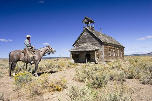 Cowboy auf einem Pferd vor einem alten Holzgebäude - Oregon - iblwot00319973