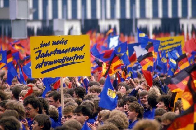 Schild - ins neue Jahrtausend atomwaffenfrei - eines FDJlers während einer Demonstration zum 1. Mai in Ost-Berlin
