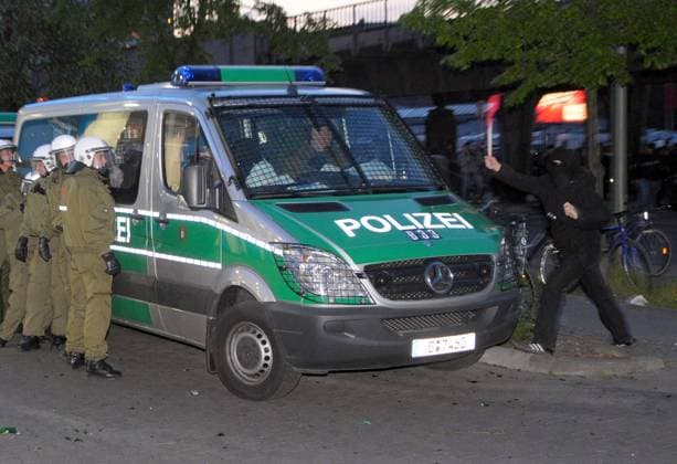Randalierer schlägt mit einem Stock auf einen Einsatzwagen der Polizei anlässlich der 1. Mai Demonstration in Berlin Kreuzberg