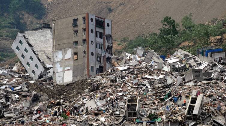 Rettungskräfte suchen nach Überlebenden in den Trümmern der zerstörten Gebäude nach dem Erdbeben in Beichuan, China - 