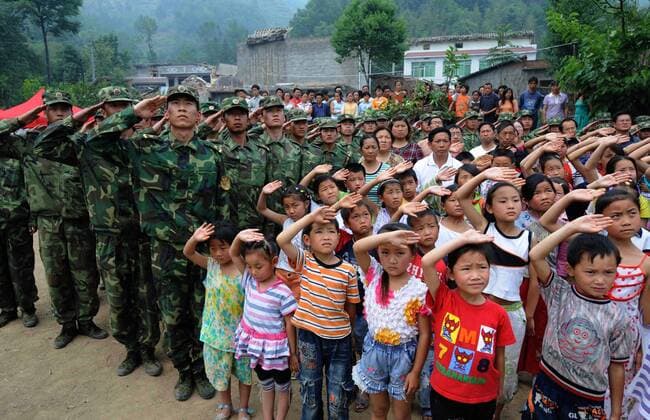 Kinder und Soldaten während eines Fahnenappells in Qingchuan im Erdbebengebiet der Provinz Sichuan - China - 