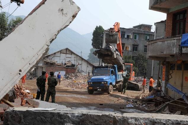 Erdbebengebiet in der Region Sichuan - Soldaten der Volksbefreiungsarmee begutachten einen Bagger bei Aufräumarbeiten in Nanba, China - 