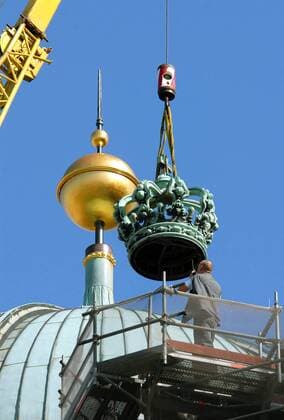 Restaurierte Königskrone wird mit einem Kran auf den Berliner Dom in Berlin gesetzt