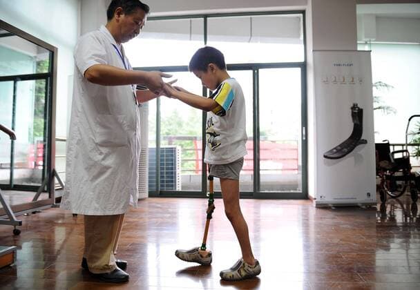 Junges Erdbebenopfer in einem Rehabilitationszentrum in Chengdu - Sichuan, China 