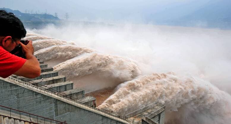 Mann fotografiert geöffnete Schleusen des Drei-Schluchten-Staudamms in den Jangtse - China - 