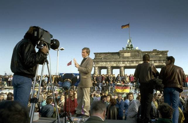 TV-Moderator und Menschen aus Ost und West feiern den Fall der Berliner Mauer vor dem Brandenburger Tor in Berlin - iblnom01063028