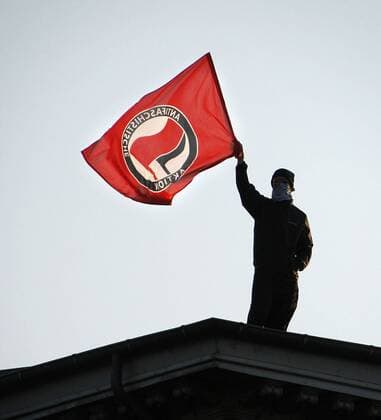 Aktivist der Antifa schwenkt die Fahne - Demonstration zum 1. Mai in Berlin Kreuzberg