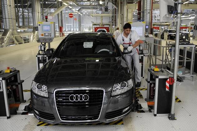 Mitarbeiter während der Fahrwerkeinstellung an einem A6 im Prüfzentrum des Audi-Werks in Neckarsulm