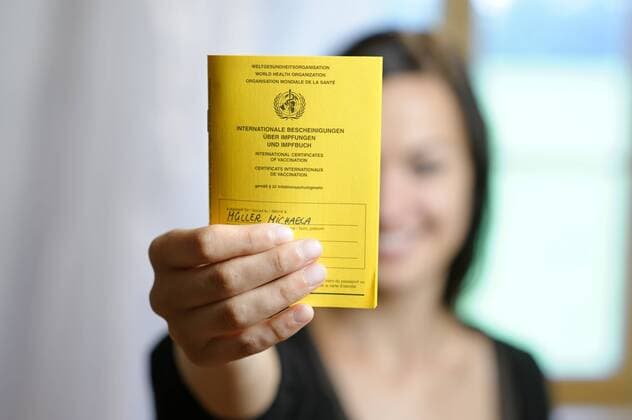  Junge Frau zeigt ihr Impfbuch, Impfpass, Impfausweis ibldwb01052193