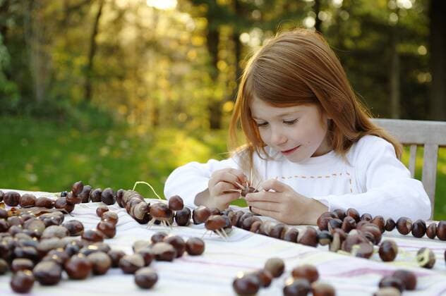 Mädchen spielt im Garten mit Kastanien, Kastanienfiguren, Kastanienmännchen ibldwb01185819