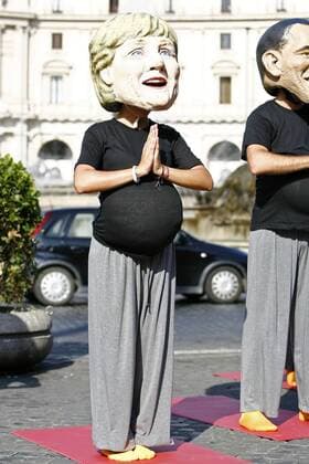 Globalisierungsgegner in der Maske von Bundeskanzlerin Angela Merkel (Deutschland CDU) entspannt sich beim morgendlichen Yoga - Teilnehmer einer Protestaktion am Rande des in L Aquila stattfindenden G8-Gipfeltreffens in Rom - 