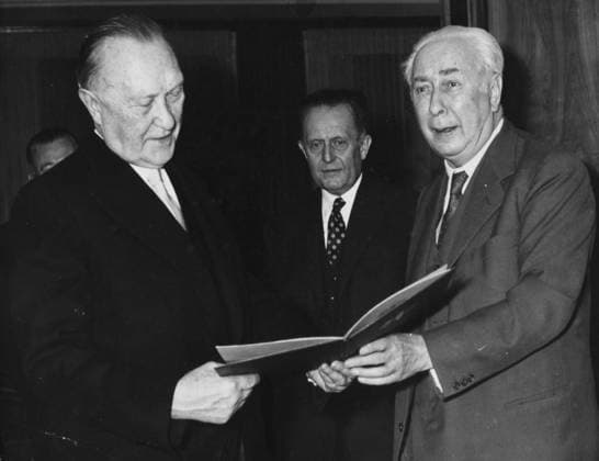 Oct 22, 1957 - Bonn, Germany - West Germany s first chancellor KONRAD ADENAUER began his career in politics as a member of the Cologne City Council, becoming lord mayor of the city. After the Nazis came to power in 1933, Adenauer, who had not hidden distaste for them, lost his positions, was forced to go into exile for a year in an abbey and was later interned in a prison camp. Adenauer was elected Chancellor of the Federal Republic of Germany on 15 September 1949. His main aim was to ensure West Germany s transition to a sovereign, democratic state. He held power for the next fourteen years and during that time played an important role in restoring good relations with France and the United States. PICTURED: PICTURED: German president THEODOR HEUSS (right) handing over a commemorative certificate to KONRAD ADENAUER who became a chancellor again. Bonn Germany  - ZUMAk09