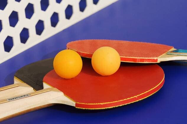 IMAGO Creative, Neujahr, Vorsätze, Sport Tischtennisschlaeger und Baelle auf einer Tischtennisplatte table tennis - racket and balls on a table tennis table BLWS175156
