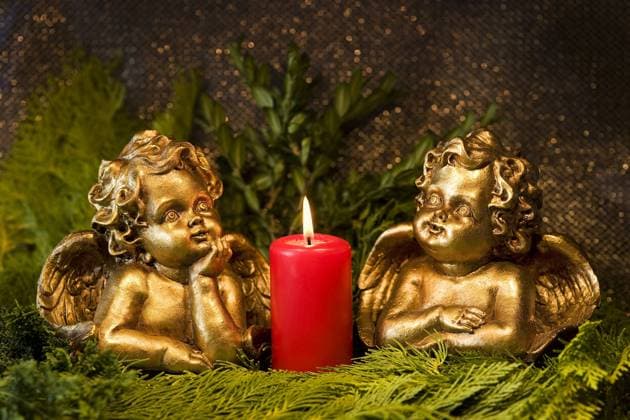 Engel und eine brennende rote Kerze iblmer01297111