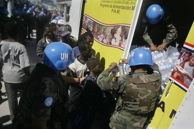 (100117) -- PORT-AU-PRINCE, Jan. 17, 2010 (Xinhua) -- United Nations peacekeepers distribute bottles of water to locals in Haitian capital Port-au-Prince on Jan. 16, 2010. International rescuers are rushing to Haiti following a devastating earthquake on Jan. 12. (Xinhua) (nxl) (4)HAITI-QUAKE-INTENATIONAL-RESCUERS 