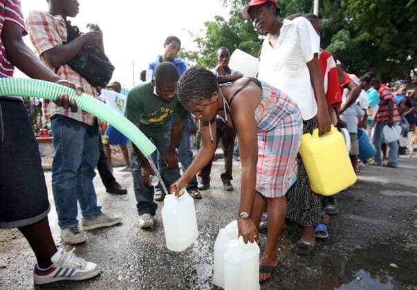 (100118) -- PORT-AU-PRINCE, Jan. 18, 2010 (Xinhua) -- Earthquake survivors get water at a makeshift residential area in Port-au-Prince, Haiti, on Jan. 17, 2010. Haitians mood was gradually tranquilized as relief goods from the international community were distrabuted. (Xinhua Yuan Man) (hdt) (1)HAITI-PORT-AU-PRINCE-DRINKING WATER 