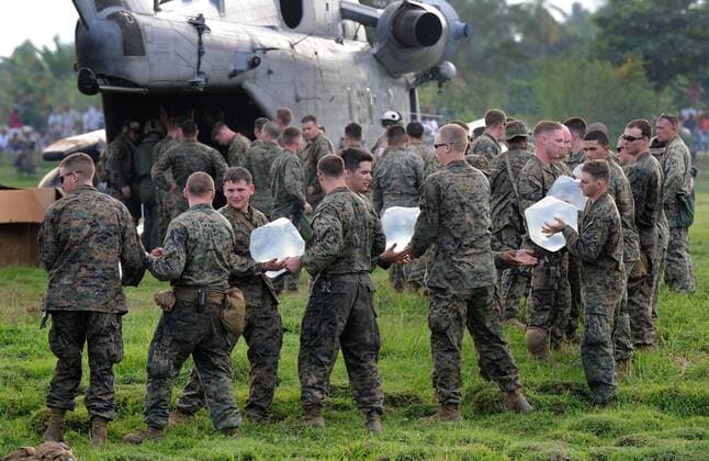 Marines unload water at a landing zone in Leogand, 25 miles outside of Port-au-Prince, January 20, 2010. The U.S. military has begun Operation United Response and has begun delivering aid to Haiti following a 7.0 magnitude earthquake that stuck the country.  HAI20100119330