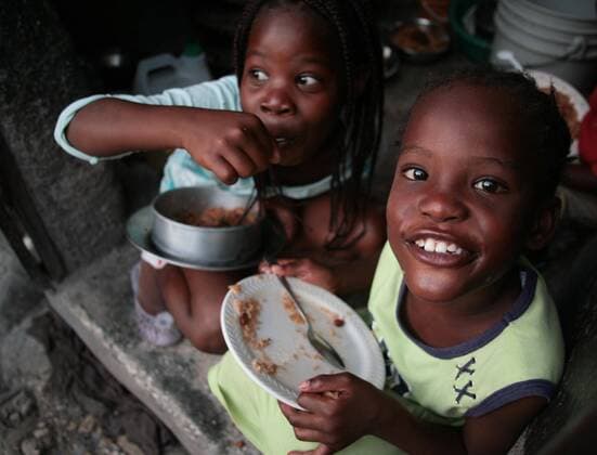 (100125) -- PORT-AU-PRINCE, Jan. 25, 2010 (Xinhua) -- A child smiles after having her meal in Port-au-Prince, capital of Haiti, Jan. 24, 2010. (Xinhua Ubaldo Gonzalez) (lmz) (11)HAITI-PORT-AU-PRINCE-QUAKE-DAILY LIFE 