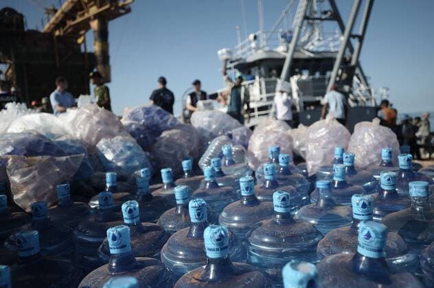 Julien Muguet IP3, Cabo Rojo, Dominikanische Republik: Französische Hilfskräfte verladen Wasserflaschen auf ein Schiff für die Opfer der Erdbebenkatastrophe in Jacmel Haiti 