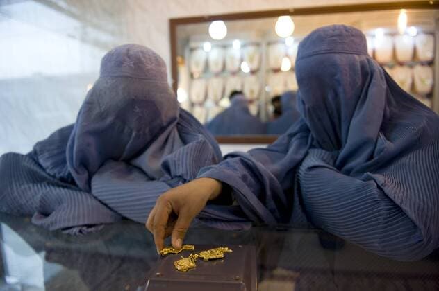 Two Afghan women wearing burkas purchase gold in a jewelry shop on February 27, 2010 in Herat, Afghanistan.  AFG20100228703