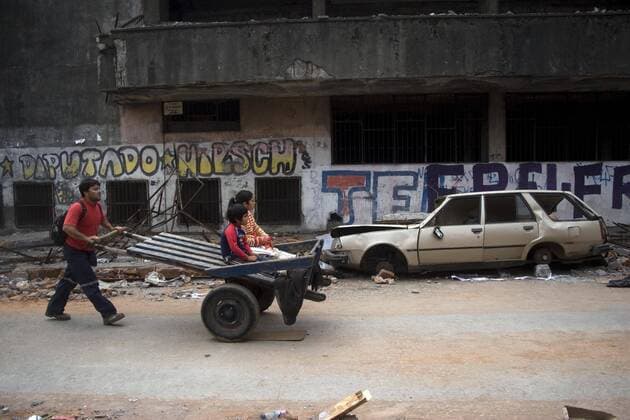 (100302) -- LOTA(CHILE), March 2, 2010 (Xinhua) -- People pass by damaged houses after tsunami and the 8.8-magnitude earthquake in Lota Port, 60km south Concepcion, Chile, March 2, 2010. Chilean President Michelle Bachelet said Tuesday that the death toll from Saturday s devastating earthquake had reached 795. (Xinhua Victor Rojas) (gxr) (9)CHILE-LOTA PORT-QUAKE-DEATH TOLL-UPDATE 