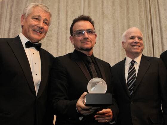 U2 lead singer Bono (C) holds the Distinguished Humanitarian Leadership Award next to Sen. John McCain (R), R-AZ.,and former Sen. Chuck Hagel, D-NE, at the Atlantic Council Annual awards dinner in Washington on April 28, 2010.  WAPG2010042803