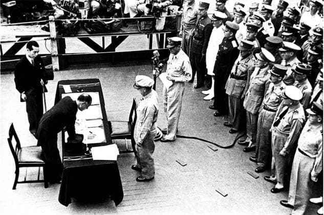 General Douglas MacArthur (at the microphone) watches the japanese representative, Mamoru Shigemitsu, sign the official Instrument of Surrender, documents on complete capitulation of Japan, September 2, 1945. The photo from the USSR central archives. Repro photo .  TASS_268963