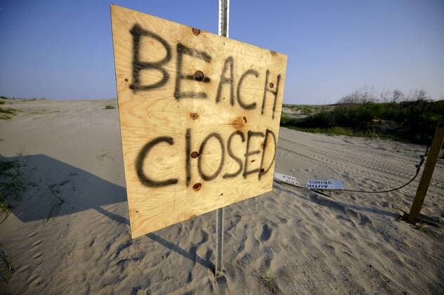 Photo taken on May 24, 2010 shows a post which says beach closed at the entrance of the Grand Isle National Park, Louisiana, US. The beach of the park was forced to close as a reslut of the oil pollution at the Mexico Gulf. (Xinhua Zhang Jun) (yc) (7)US-OIL-POLLUTION-GRAND ISLE 