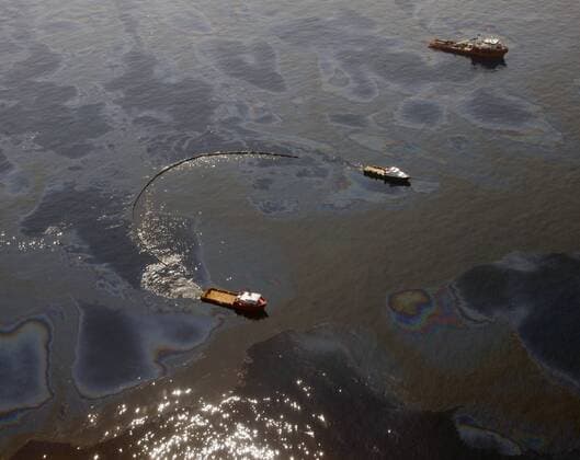 Work boats pull booms to skim oil at the site of the BP Deepwater Horizon oil leak in the Gulf of Mexico May 29, 2010. BP admitted that its top kill operation had failed to plug the well, and the company is proceeding with other efforts to stop the leak.  NOP2010052911