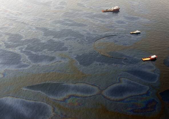 Work boats pull booms to skim oil at the site of the BP Deepwater Horizon oil leak in the Gulf of Mexico May 29, 2010. BP admitted that its top kill operation had failed to plug the well, and the company is proceeding with other efforts to stop the leak.  NOP2010052903