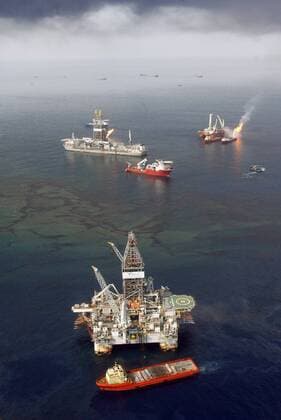 Oil shines on the surface of the Gulf of Mexico as workboats gather near a rig drilling a relief well, front, and a controlled burn, back right and left, at the BP Deepwater Horizon oil spill site June 19, 2010. BP continued its attempts to stem the flow of oil from its rig, which exploded and sank in the Gulf in April.  NOP2010061904