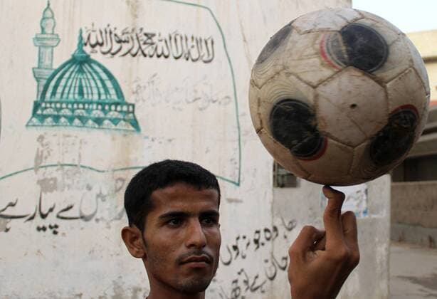 Freizeit Trend: Football Freestyle KARACHI PAKISTAN Man playing with a football in the slum area in Karachi - 