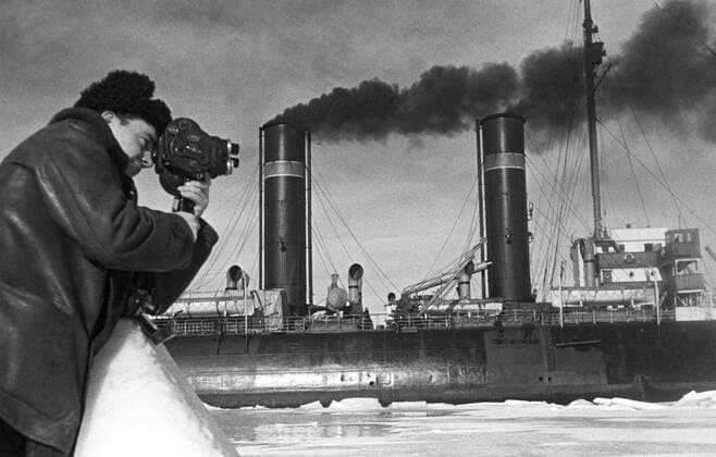 Photographer Mark Troyanovsky takes a picture of the icebreaker - Yermak - and the crewmen of Ivan Papanin s expedition.  1150105