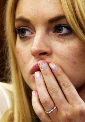 Actress Lindsay Lohan reacts following her sentencing by Superior Court Judge Marsha Revel during a probation status hearing in Beverly Hills, California on July 6, 2010. Revel sentenced Lohan to 90 days in jail Tuesday after ruling she violated probation in a 2007 drug case by failing to attend court-ordered alcohol education classes. An explicative is seen on Lohan s fingernail on her middle finger  LAP2010070684R