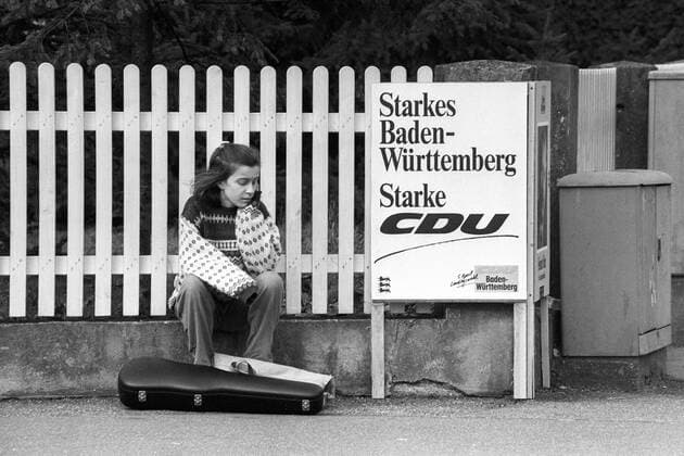 Mädchen mit Geigenkoffer neben einem Wahlplakat der CDU zur Landtagswahl in Baden-Württemberg