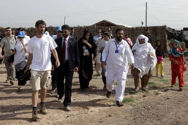 (100907) -- NOWSHERA (PAKISTAN), Sept. 7, 2010 (Xinhua) -- UN High Commissioner for Refugees (UNHCR) Goodwill Ambassador Angelina Jolie (C, in black scarf) arrives for a visit to a makeshift camp for Pakistani displaced by floods in the Mohib Bhanda area of northwest Pakistan s Nowshera, on Sept. 7, 2010. Jolie visited Pakistan to draw world s attention to the conditions of 21 million people influenced by the worst-ever floods in Pakistan, the UN refugee agency said. (Xinhua Umar Qayyum) (lr) (2)PAKISTAN-NOWSHERA-UNHCR GOODWILL AMBASSADOR-ANGELINA JOLIE-VISIT 