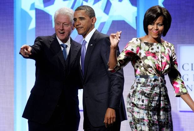 Former President Bill Clinton (L), U.S. President President Barack Obama and First Lady Michelle acknowledge the cheering audience during the closing plenary session at the sixth annual meeting of the Clinton Global Initiative on September 23, 2010 in New York.  NYP20100923334