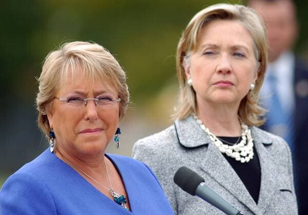 U.S. Secretary of State Hillary Clinton (R) looks on as President of Chile Michelle Bachelet speaks after Clinton arrived in Santiago on March 2, 2010. Sec. Clinton stopped in Chile to offer communications equipment and U.S. aid after an 8.8 magnitude earthquake devastated the country on February 27.  CHL20100302702