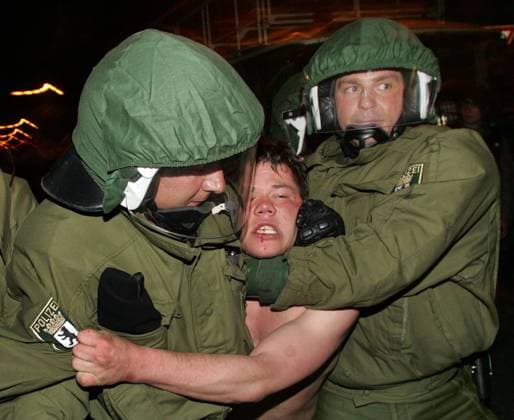 Polizei-Beamte führen am Samstag (30.04.2005) in Berlin auf dem Boxhagener Platz im Stadtteil Friedrichshain während der Ausschreitungen anlässlich der Walpurgisnacht-Feierlichkeiten einen festgenommenen Chaoten ab
