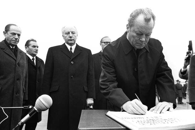 Bundeskanzler Willy BRANDT, rechts, trägt sich in ein Buch ein, mit ernster Miene, im Hintergrund steht Bundesaussenminister Walter SCHEEL, vor der Kranzniederlegung vor dem Denkmal der Helden des Ghettos, vor dem historischen Kniefall in Warschau 1970, SW-Aufnahme, 07.12.1970