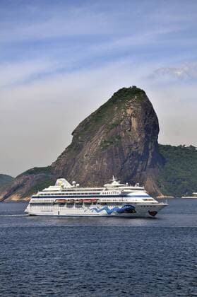 Kreuzfahrtschiff des deutschen Anbieters AIDA Cruises passiert den Zuckerhut in der Bucht Bahia de Guanabara, Einfahrt in den Hafen von Rio de Janeiro, Brasilien, Südamerika iblflk01769606