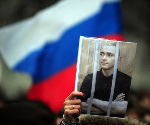 ITAR-TASS: MOSCOW, RUSSIA. DECEMBER 26, 2010. Russian flag and a portrait of Mikhail Khodorkovsky seen during the anti-racism rally held under the slogan - Russia is open to everyone! - in central Moscow. Several thousand people protest against ethnic clashes that have rocked Moscow this month following the deadly shooting of a soccer fan.  RE0DEAAD