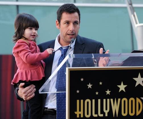 Actor Adam Sandler holds his daughter Sunny as he makes comments during an unveiling ceremony honoring him with the 2,431st star on the Hollywood Walk of Fame in Los Angeles on February 1, 2011.  LAP2011020114