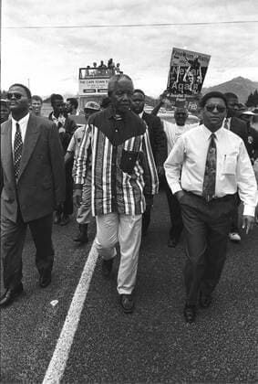 IMAGO History, Ende der Apartheid in Südafrika: 1990-1994 Nelson Mandela reeancts his walk from the prison CAPE TOWN, SOUTH AFRICA - 1994: Four years after being released from the Victor Verster prison (now the Groot Drakenstein Correctional Facility) then President Nelson Mandela, surrounded by supporters and media, reenacts his walk from the prison on Wemmershoek road, Paarl in February 1994. On his left is Rev. Allan Boesak ( Gallo0005786